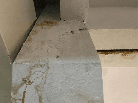 Fissuração e degradação superficial associadas a um caminho de umidade.